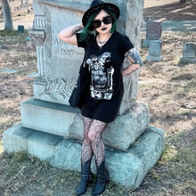 Laden Sie das Bild in den Galerie-Viewer, Person in gothic attire standing in a cemetery next to a gravestone. Wearing discount cemetery tshirt dress with picture of blow mold tombstone with "Discount Cemetery" on the stone. A skeleton hand holding a squeegee and a paink bucket thaty says print fast die slow. 