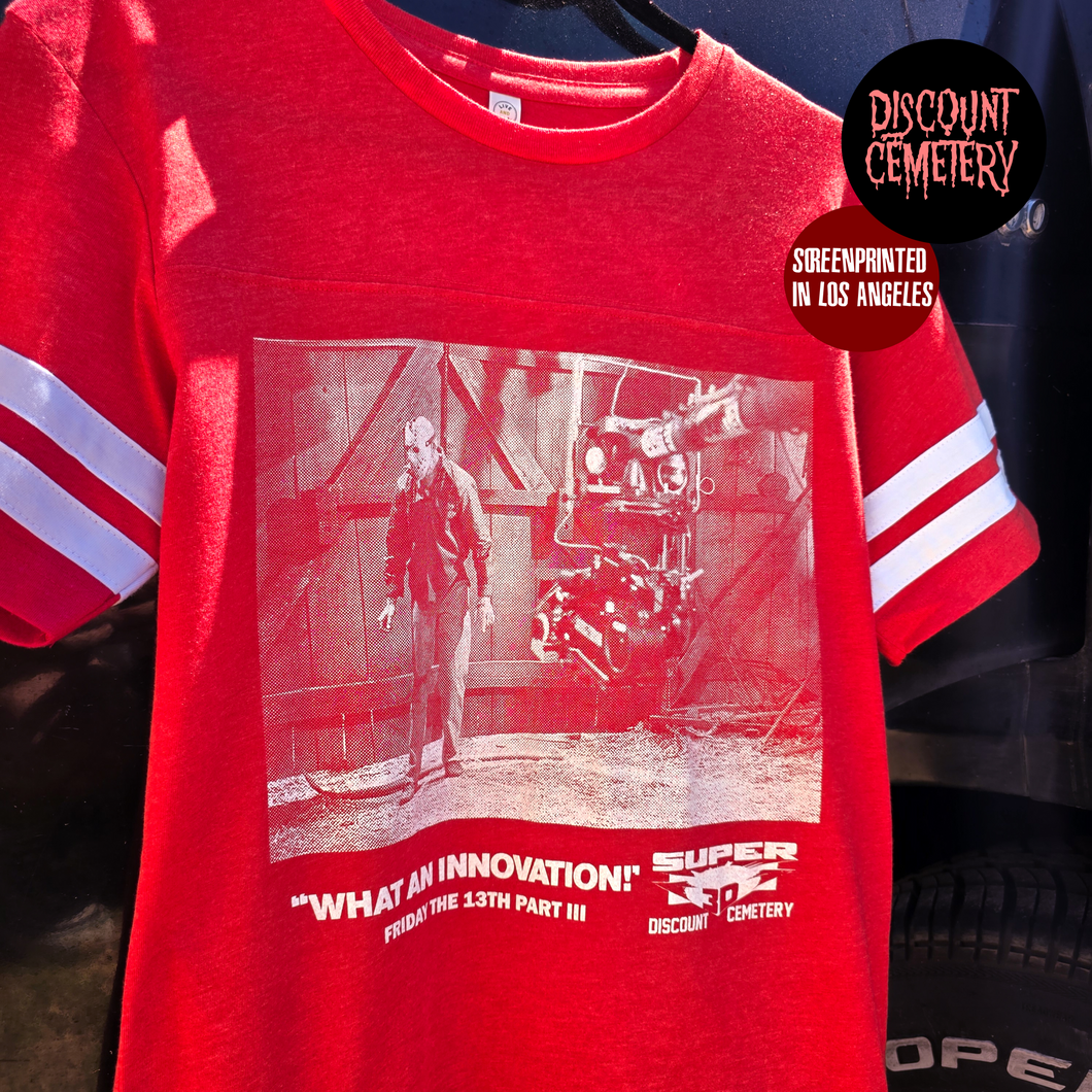 Red jersey style t-shirt with graphic design and text, featuring 'Discount Cemetery' branding.